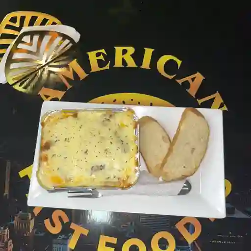 Lazaña: boloñesa acompañada de pan
